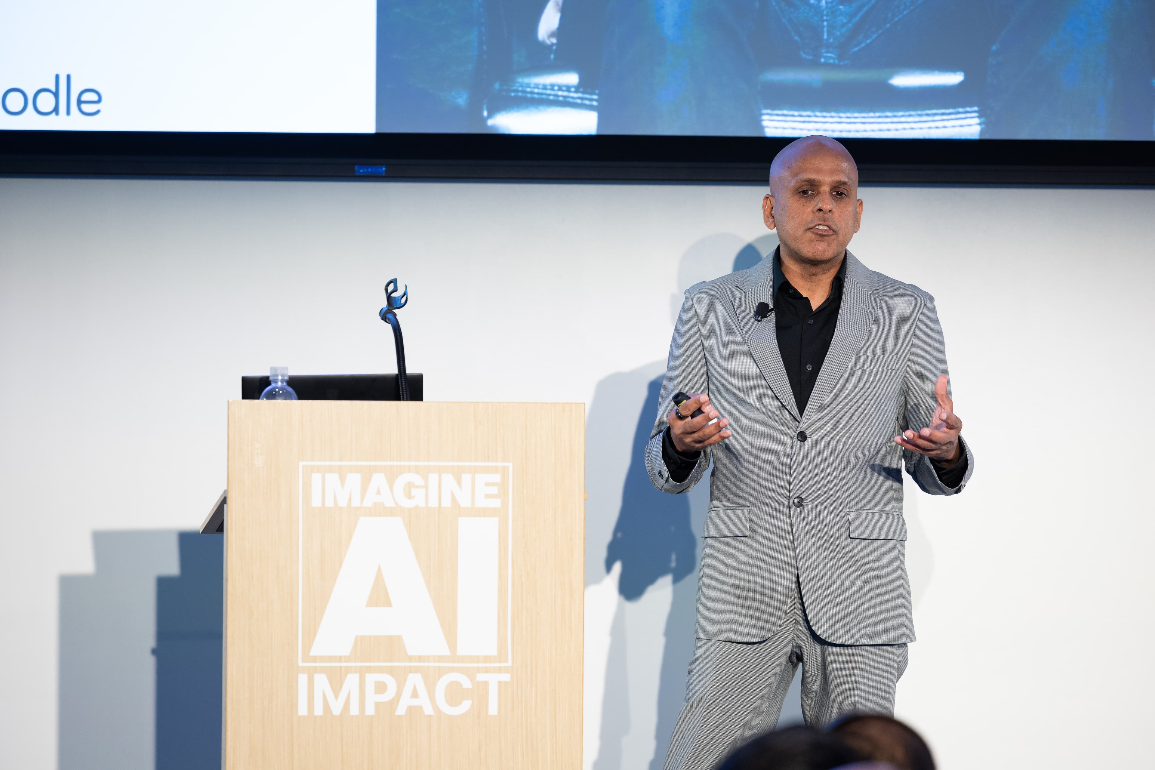 Manuj Aggarwal speaking at an IMAGINE AI IMPACT keynote.
